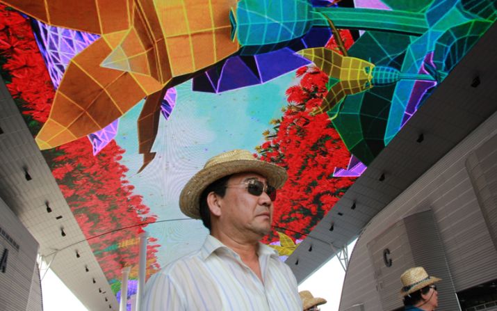 A visitor stands beneath the giant interactive screen at the Expo. 