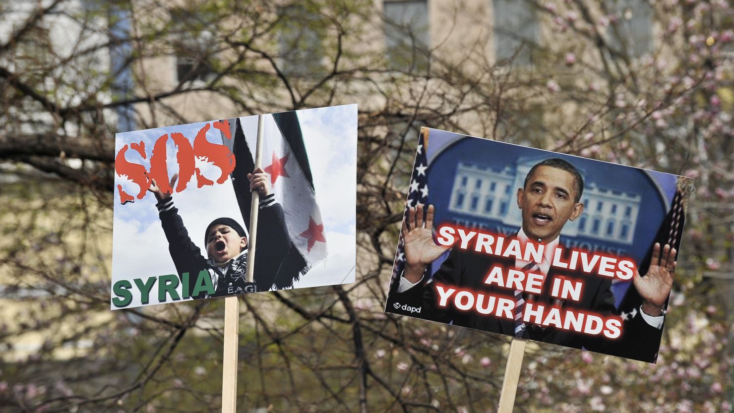 People hold signs during a rally in support of the Syrian opposition at Lafayette Park in front of the White House in March.