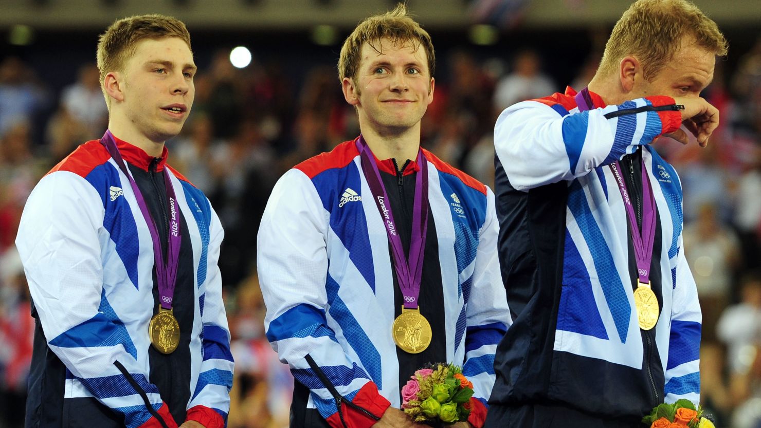 Chris Hoy wipes away a tear as he shares the podium with teammates Philip Hindes and Jason Kenny.  