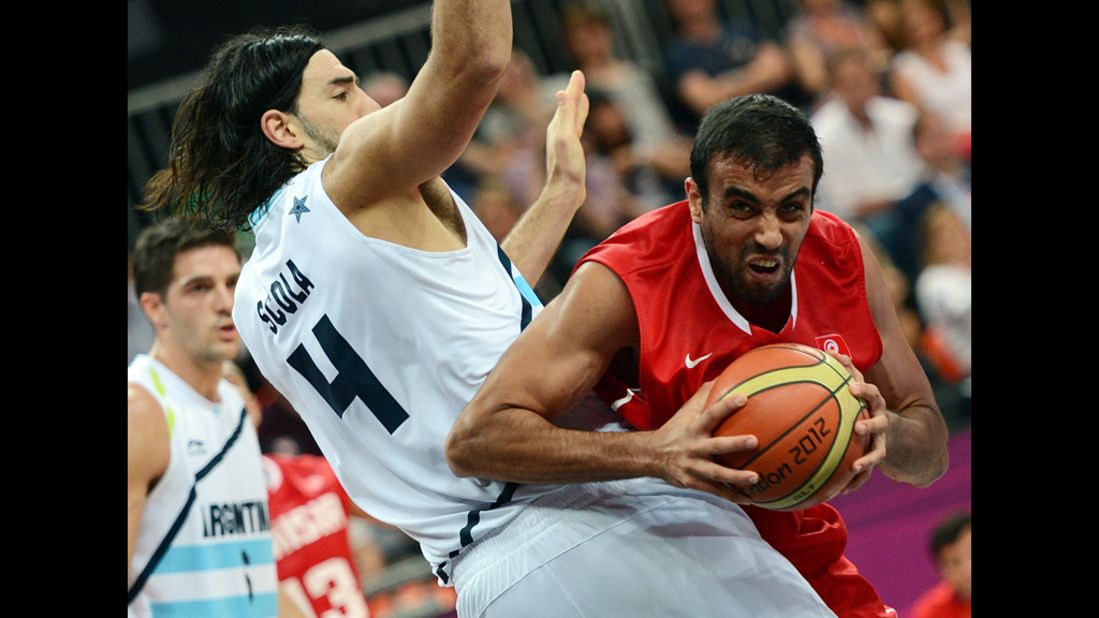 Tunisian forward Makram Ben Romdhane, right, vies with Argentine forward Luis Scola during the men's preliminary round group A basketball match.