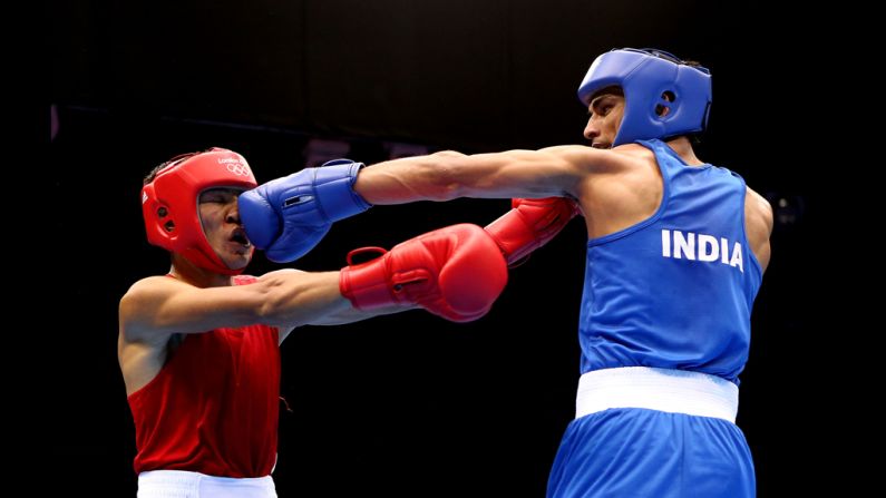 Kazakhstan's Gani Zhailauov, left, takes a hit from India's Bhagwan Jai during the men's lght bxing.