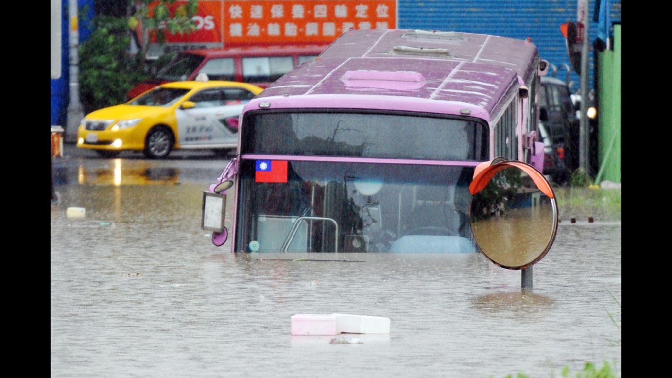 A bus sits half submerged on a flooded road in New Taipei City.