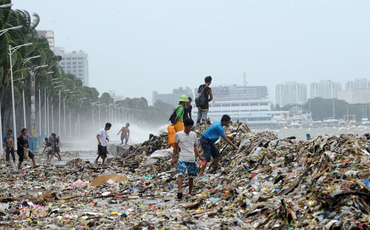 People pick up recyclable materials among the trash washed ashore along's Manila's Roxas Boulevard. 