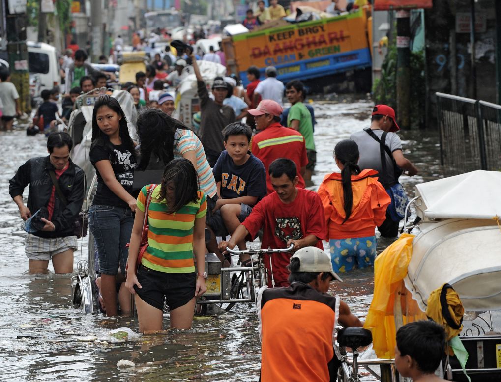 Residents wade through a flooded street in Navotas in suburban Manila. Forty-four evacuation centers have been opened due to flooding. 
