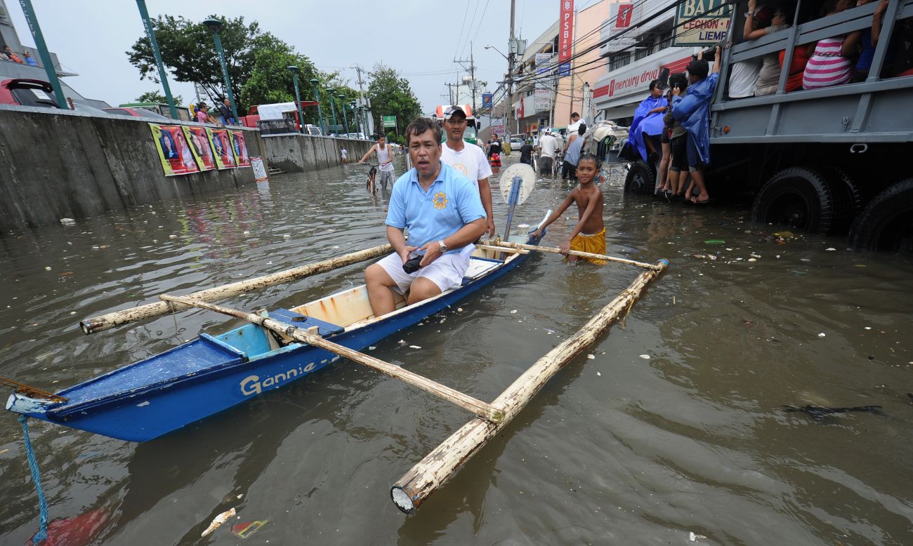 A resident rides in a banca on a flooded street in Navotas. 