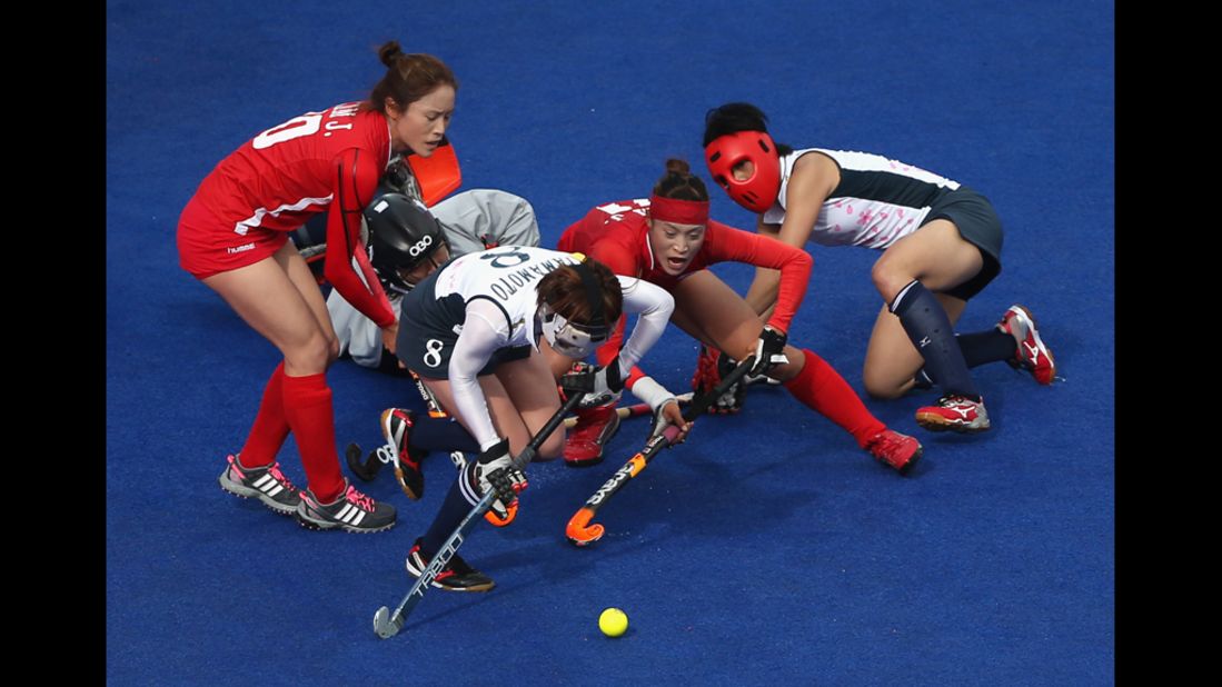 South Korea, in red, and Japan do battle during the women's field hockey match Thursday. 