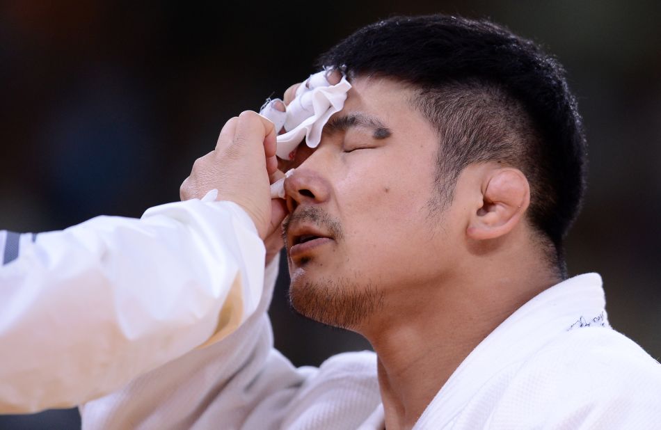 South Korea's Hwang Hee-Tae gets treated for an injury during a men's under 100-kilogram judo contest match.