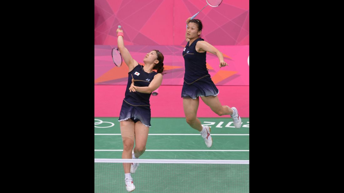 Mizuki Fujii, left, and Reika Kakiiwa, right, of Japan play a shot during their semifinal mixed doubles badminton match against Canada's Michelle Li and Alex Bruce.