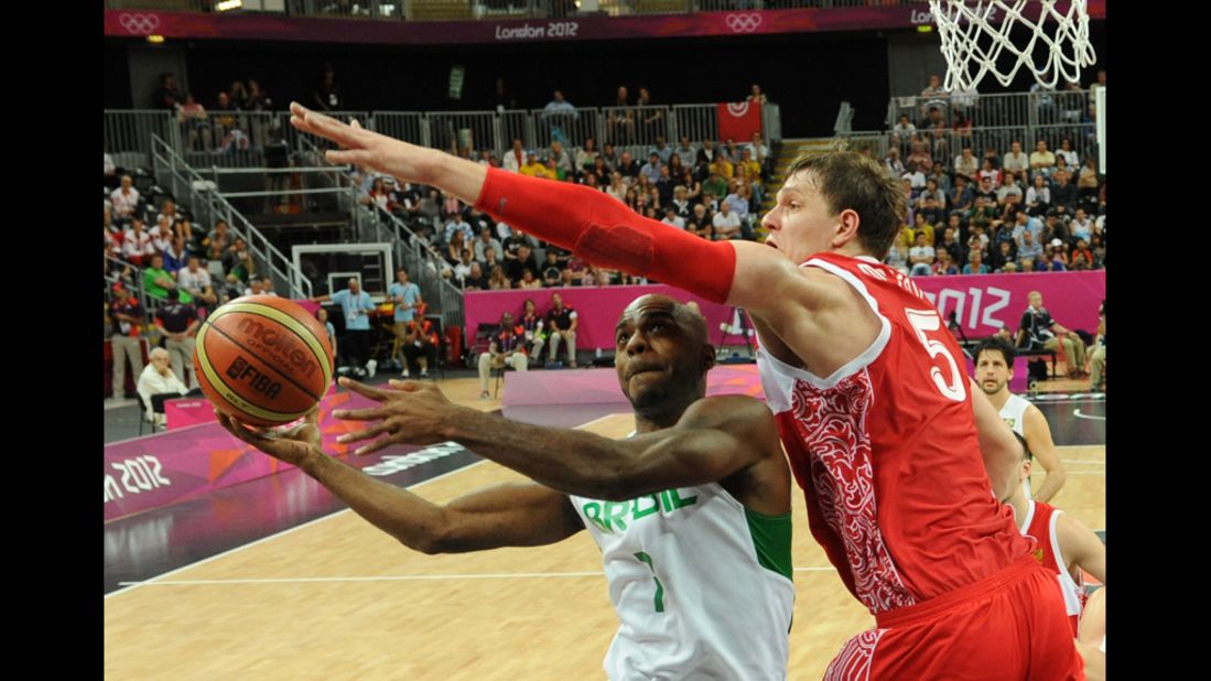 Brazilian forward Larry Taylor, left, tries to get past Russian center Timofey Mozgov, right, during the men's preliminary round basketball match.