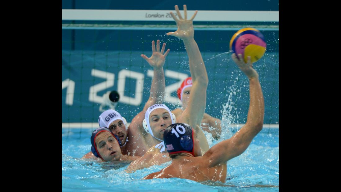 Great Britain's Rob Parker, center, competes with Tim Hutten, right, of the United States in the men's water polo preliminary match. The U.S. team won 7-13.<br />