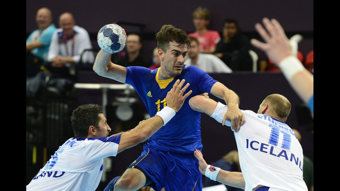 Sweden's center back Dalibor Doder, center, vies with Icelandic players during the men's preliminary group A handball match.