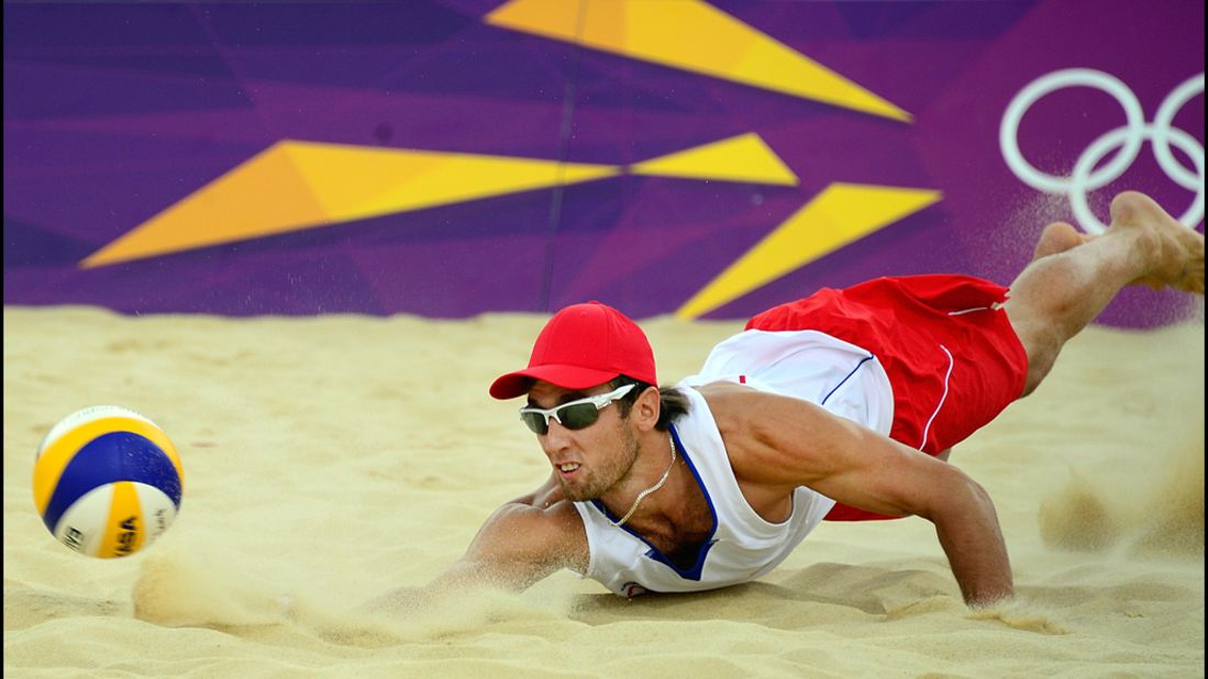 Poland's Grzegorz Fijalek dives for the ball during a beach volleyball match.
