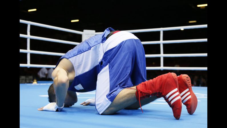 Algeria's Samir Brahimi kneels in prayer following his loss in the men's flyweight boxing match to Misha Aloian of Russia.