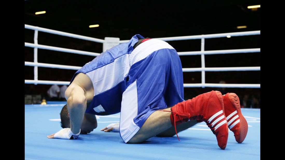 Algeria's Samir Brahimi kneels in prayer following his loss in the men's flyweight boxing match to Misha Aloian of Russia.