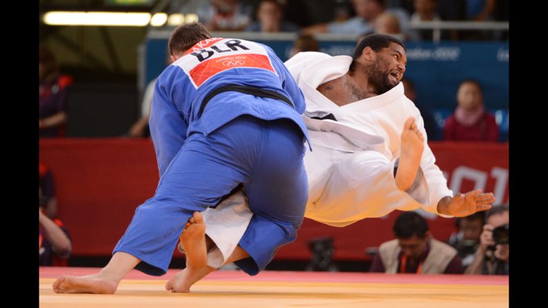 Ihar Makarau, left, of Belarus competes with Cuba's Oscar Brayson during the men's over 100-kilogram judo repechage match.