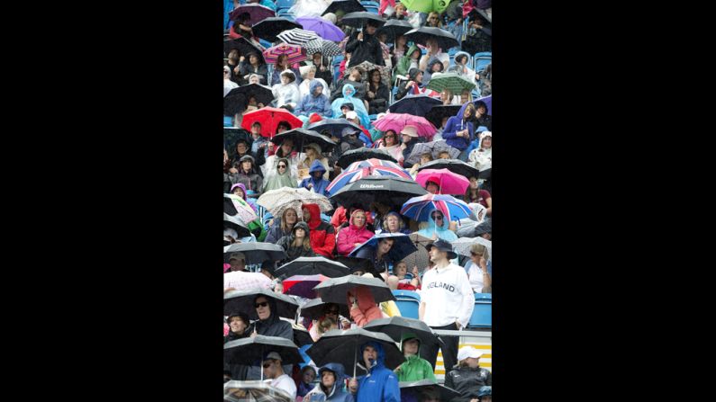 Spectators take cover during the dressage preliminaries at Greenwich Park in London.