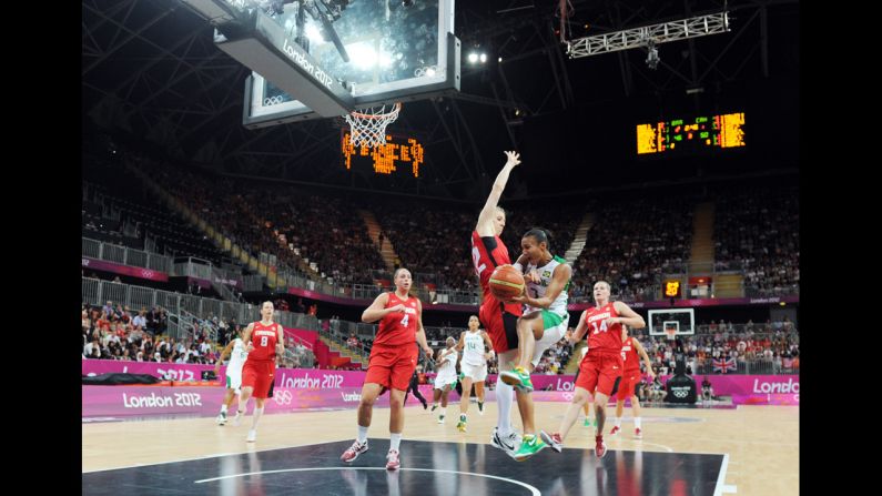 Brazilian guard Joice Rodrigues, second from right, vies with Canadian forward Lizanne Murphy during a women's preliminary round basketball match.