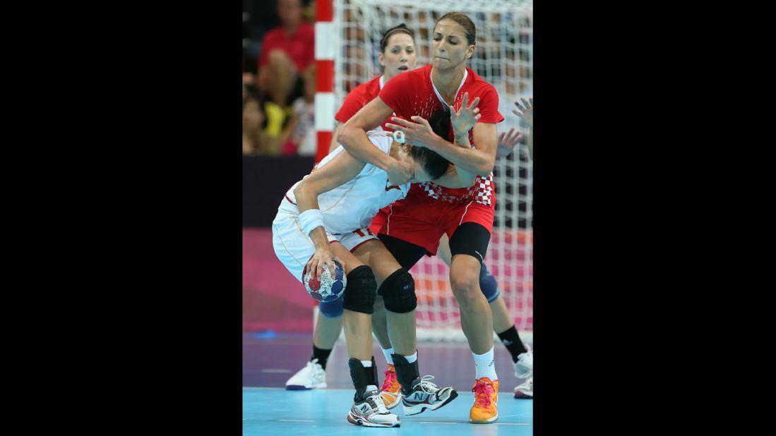 Croatia's Andrea Penezic, right,  grabs the face of Bojana Popovic of Montenegro during the women's handball preliminaries.