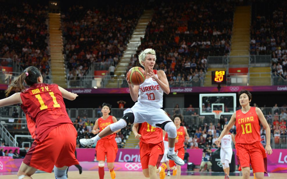 Turkish guard Isil Alben, center, jumps with the ball during the women's preliminary round basketball match between Turkey and China on Friday.