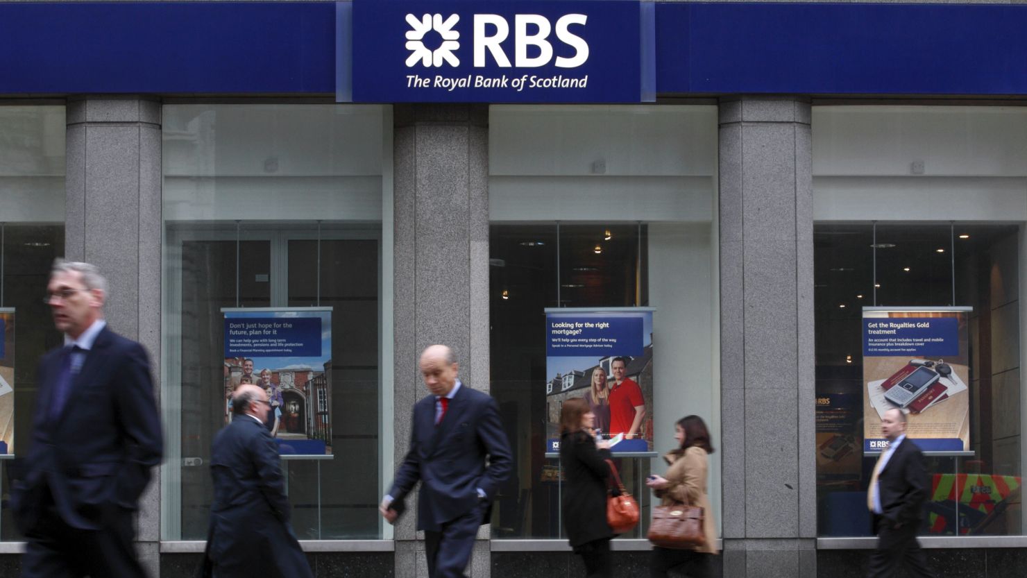 Pedestrians walk past a branch of the Royal Bank of Scotland in London on January 30, 2012. 