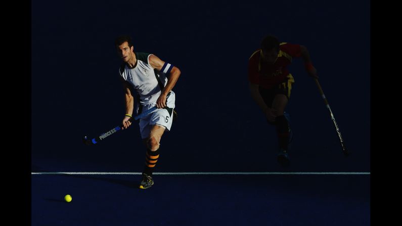 South Africa's captain Austin Smith, left, advances the ball forward with Roc Oliva of Spain in pursuit during the men's hockey match.