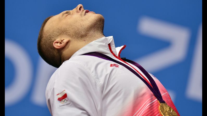 Poland's Adrian Edward Zielinski poses on the podium with his gold medal after winning the men's 85 kilogram group A weightlifting event.
