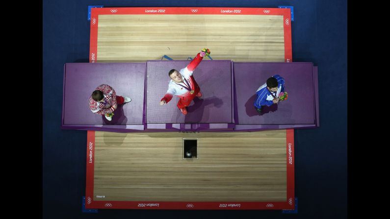 Adrian Edward Zielinski of Poland celebrates on the podium after winning the gold medal after the men's 85 kilogram weightlifting final.