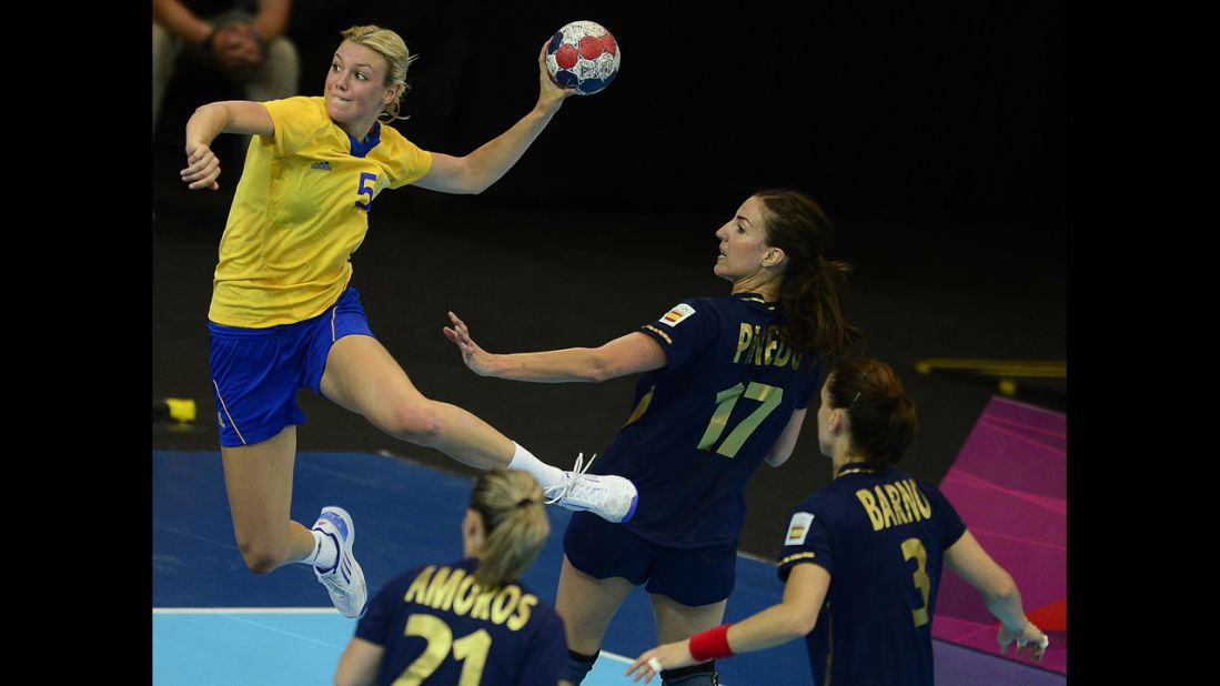 Sweden's pivot Hanna Fogelstrom, left, jumps to shoot during the women's preliminary group B handball match against Spain.