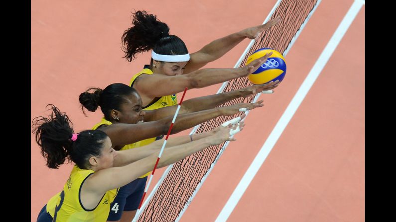 From left, Brazil's Sheilla Castro, Fabiana Claudino and Paula Pequeno attempt to block during a women's preliminary pool volleyball match between Brazil and China.