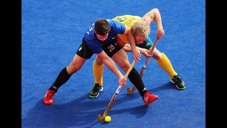 Gonzalo Peillat of Argentina battles with Matthew Butturini of Australia during a men's hockey preliminary match.