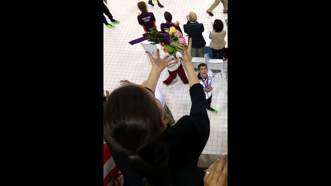Michael Phelps throws his flowers to his sister Hilary Phelps after the medal ceremony in the men's 200-meter individual medley final.