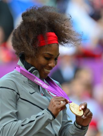 Williams admires her gold medal during the medal ceremony after defeating Sharapova in the women's singles match.