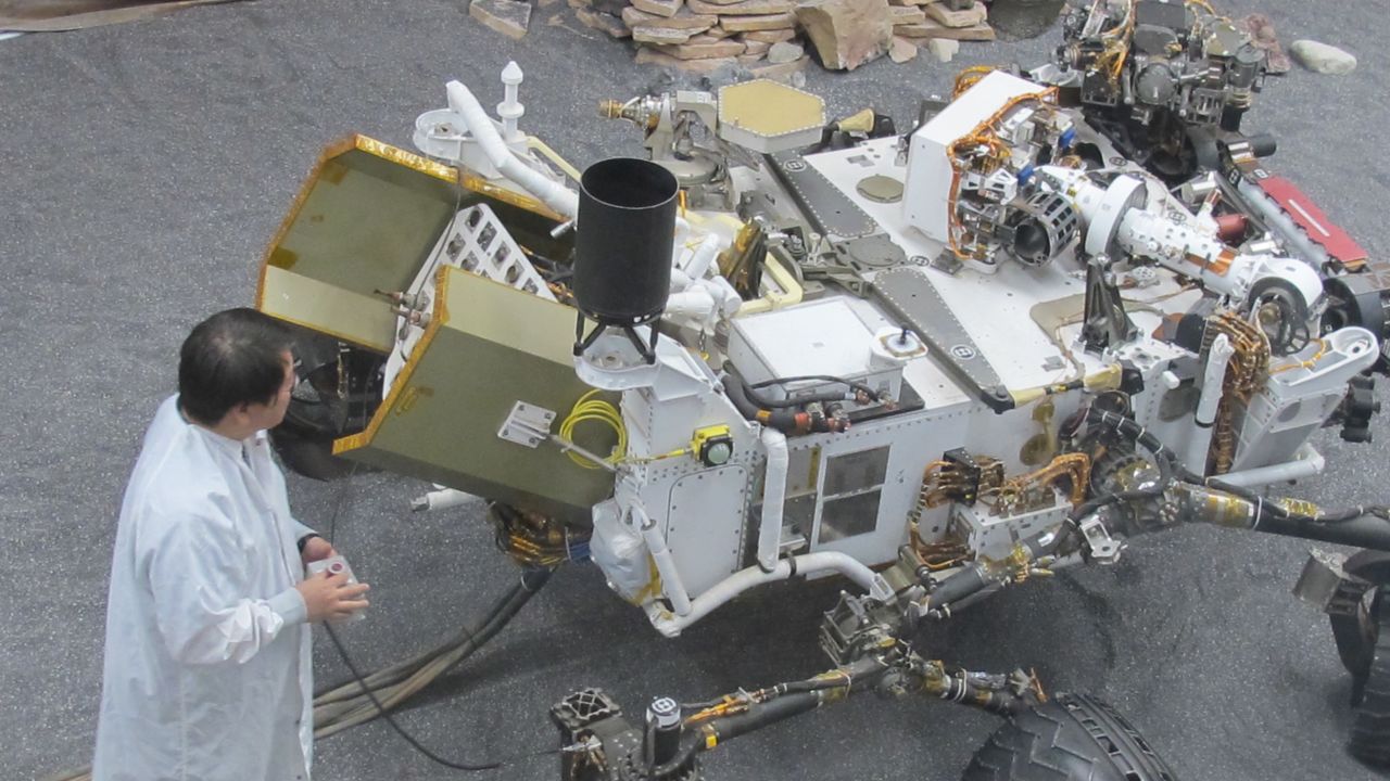 James Wang, test conductor for Curiosity, with the test model of the rover used for experiments on Earth.