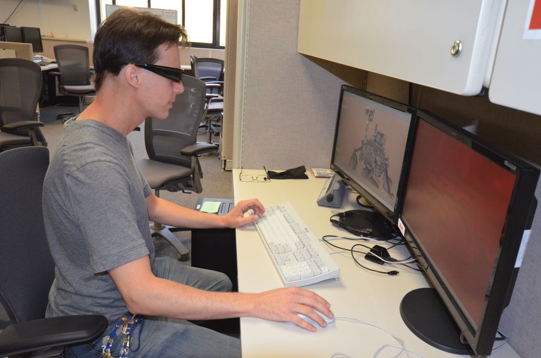 Scott Maxwell wears 3-D glasses to simulate driving a Mars rover at JPL's Mission Operations area.