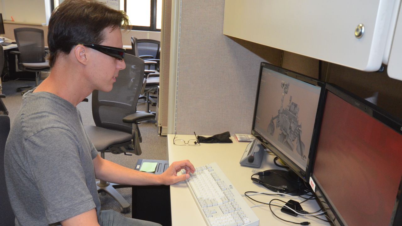 Scott Maxwell wears 3-D glasses to simulate driving a Mars rover at JPL's Mission Operations area.