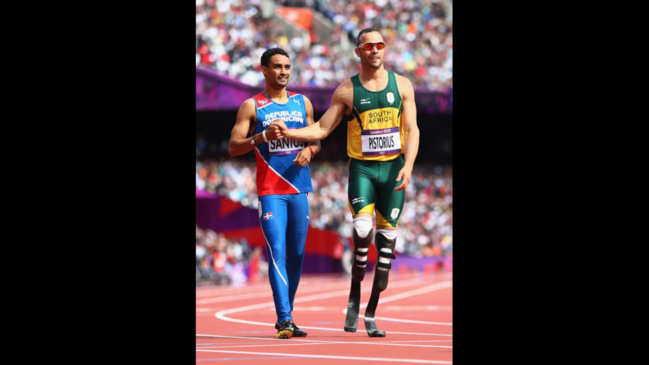 Luguelin Santos, left, of the Dominican Republic shakes hands with Oscar Pistorius of South Africa after competing in the preliminary heat of the men's 400-meter on Saturday.