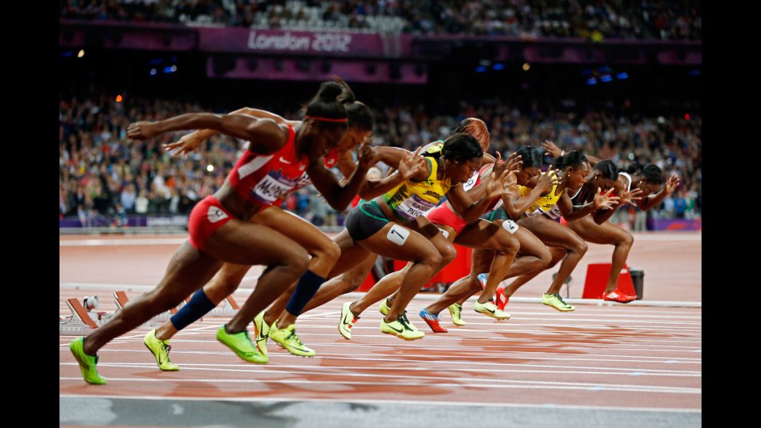 Sprinters explode out of the starting blocks in the in the women's 100-meter final.