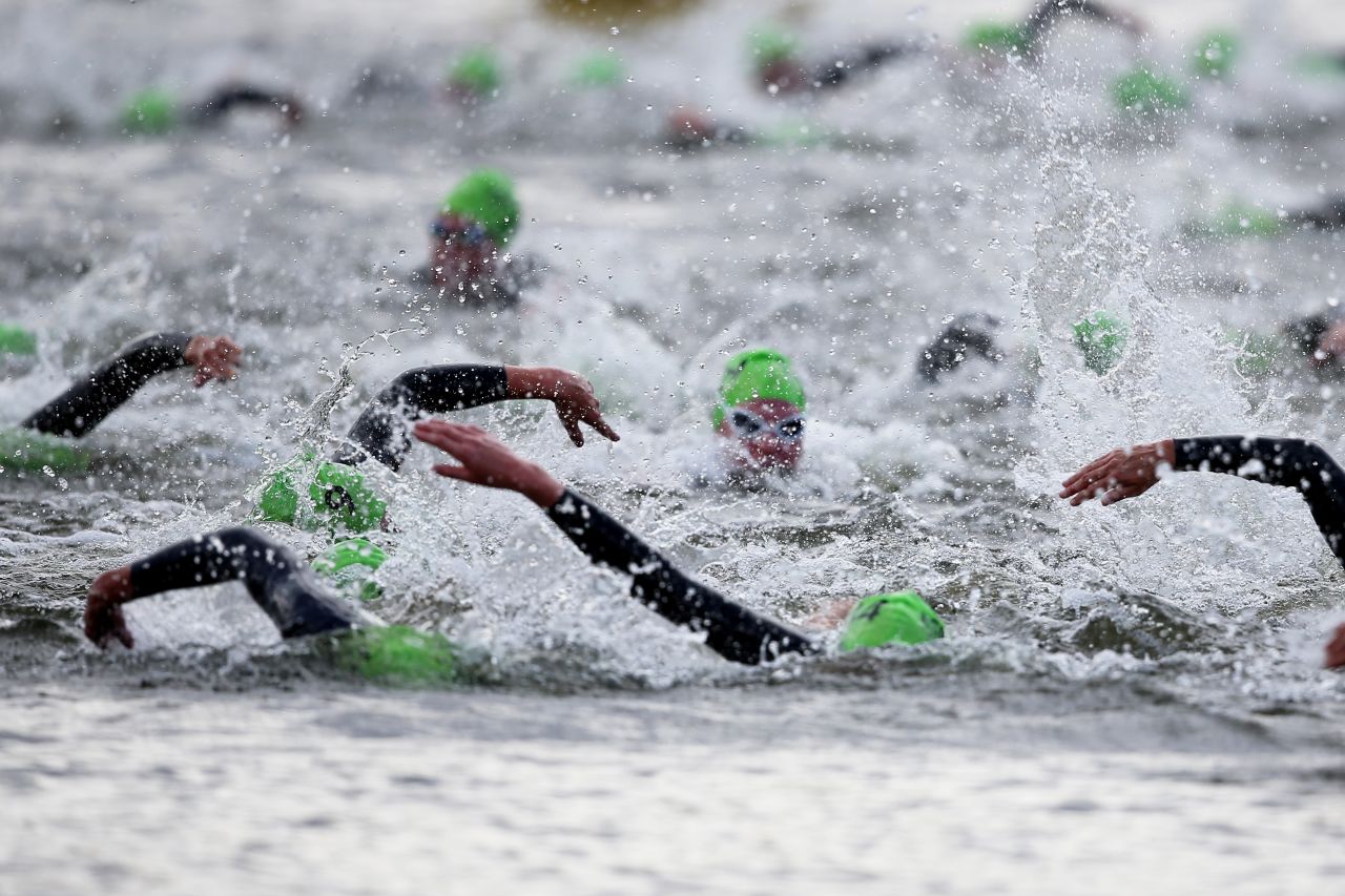 Athletes swim the first leg of the women's triathlon during Saturday.