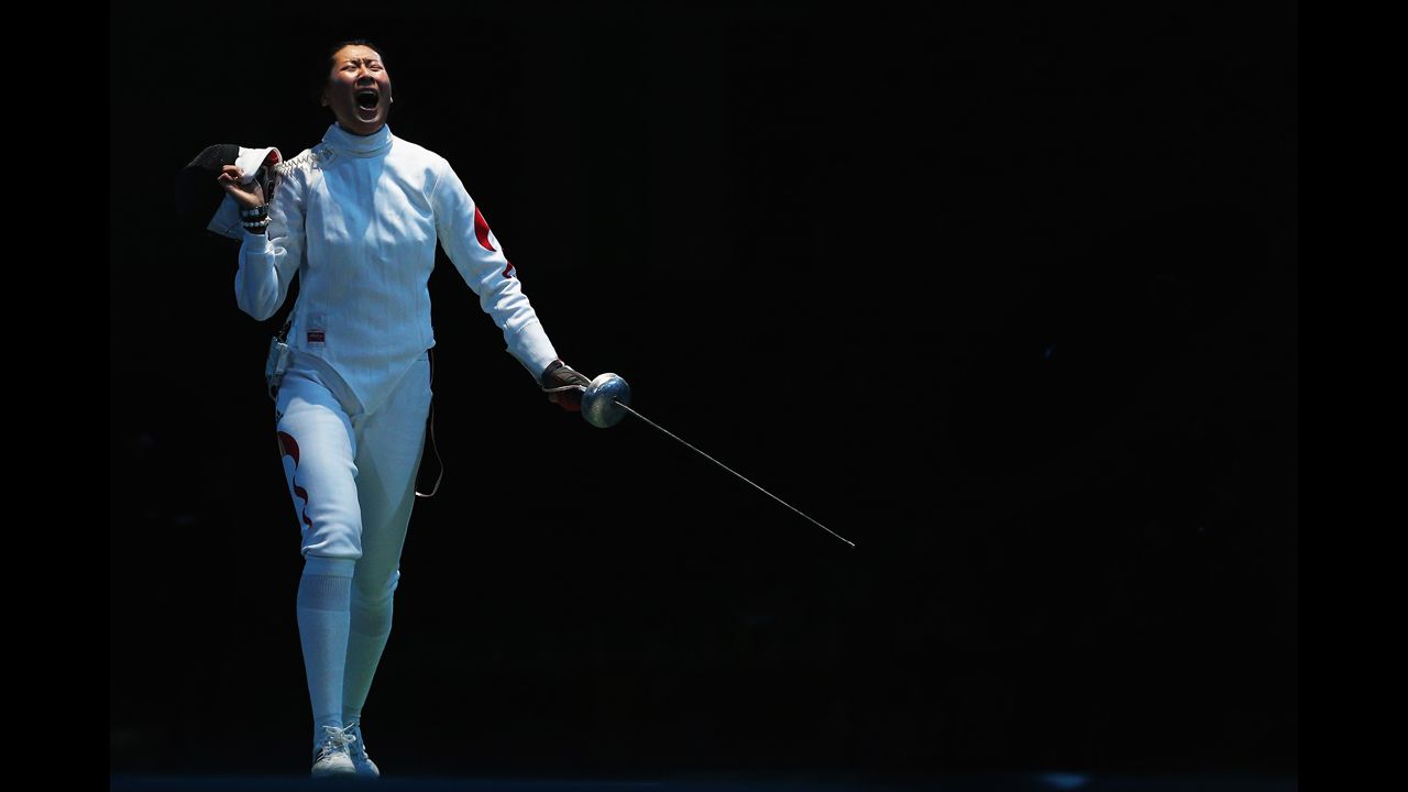 Yujie Sun of China celebrates after beating Britta Heidemann of Germany during the women's epee team fencing quarterfinals.