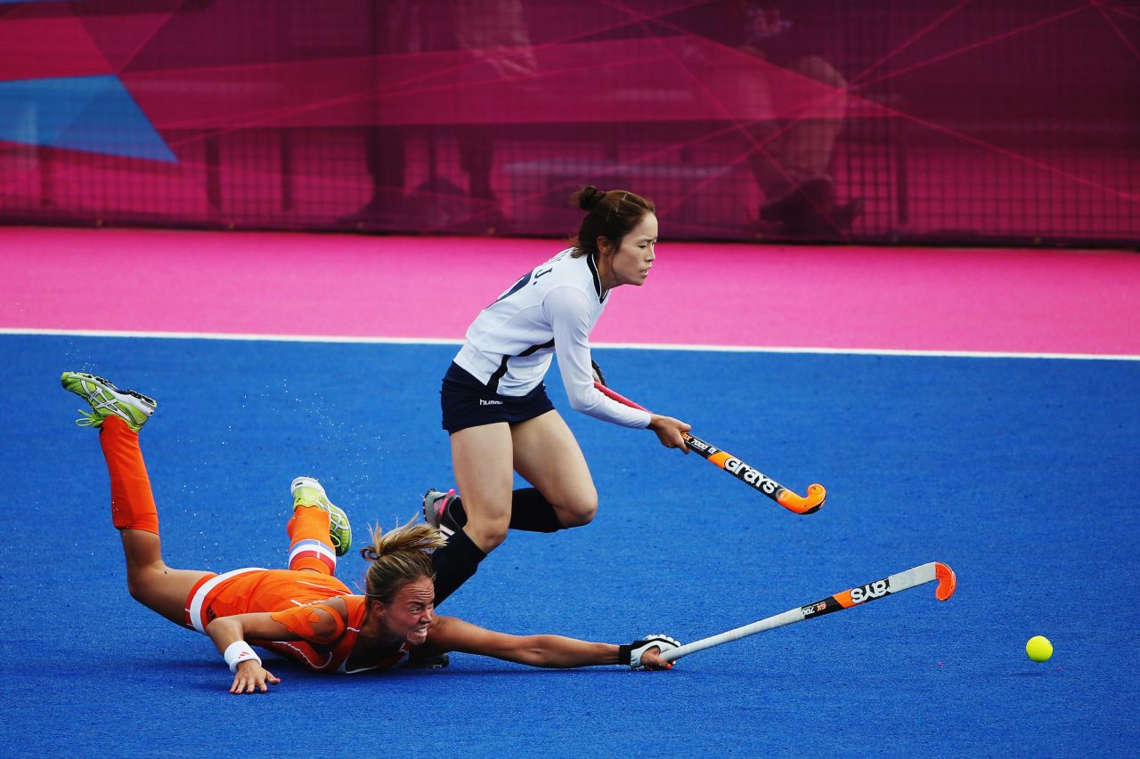 Captain Maartje Paumen of the Netherlands challenges Kim Jong Hee of South Korea during a women's hockey match.