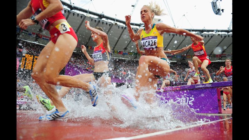 Runners compete in a women's 3000-meter steeplechase heat at Olympic Stadium.