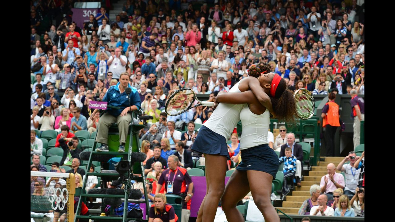 Venus Williams, left, and Serena Williams embrace after winning the women's doubles gold medal match on Sunday.