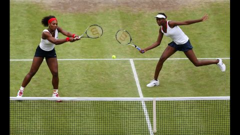 Serena Williams, left, and Venus Williams, right, return a shot during the women's doubles final.