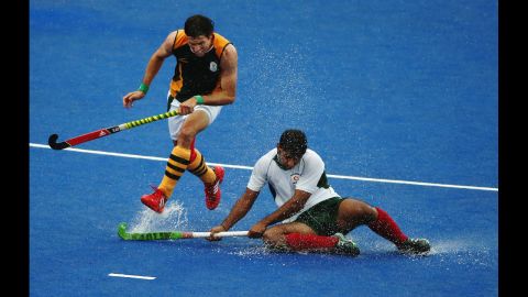 Thornton McDade of South Africa and Muhammad Imran of Pakistan challenge for the ball during a men's field hockey match.