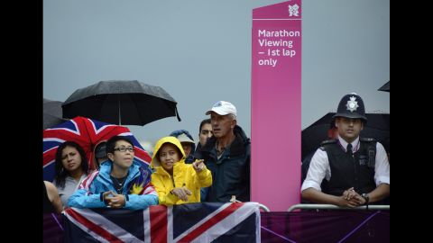 Spectators view the course as rain falls during the women's marathon race.
