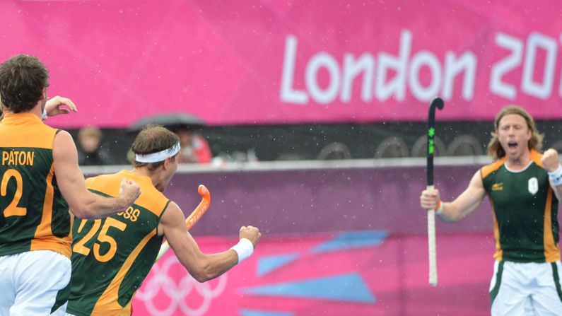 Members of the South African men's field hockey team celebrate a goal against Pakistan during a preliminary round match.