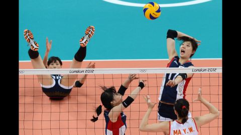 South Korea's Yang Hyo-Jin, top right, spikes as China's Ma Yunwen, bottom right, attempts to block during the women's preliminary pool B volleyball match.