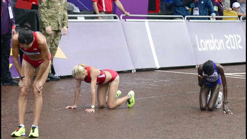 Namibia's Helalia Johannes, right, and other competitors begin to recover after finishing the women's marathon.