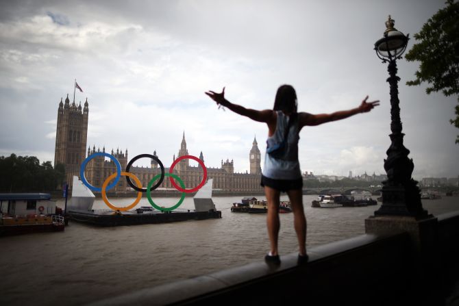 A tourist enjoys the view of giant Olympic rings floating in the River Thames opposite Parliament on Sunday, August 5, in London, England.