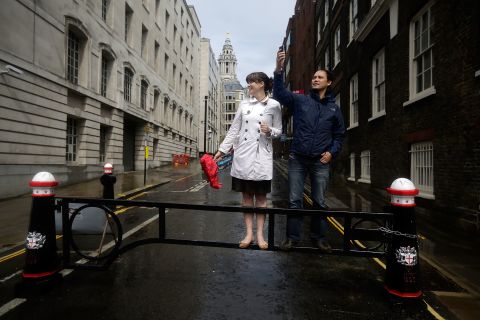 Despite the rain, two spectators eagerly await a view of runners in the women's marathon near St. Paul's Cathedral in London.
